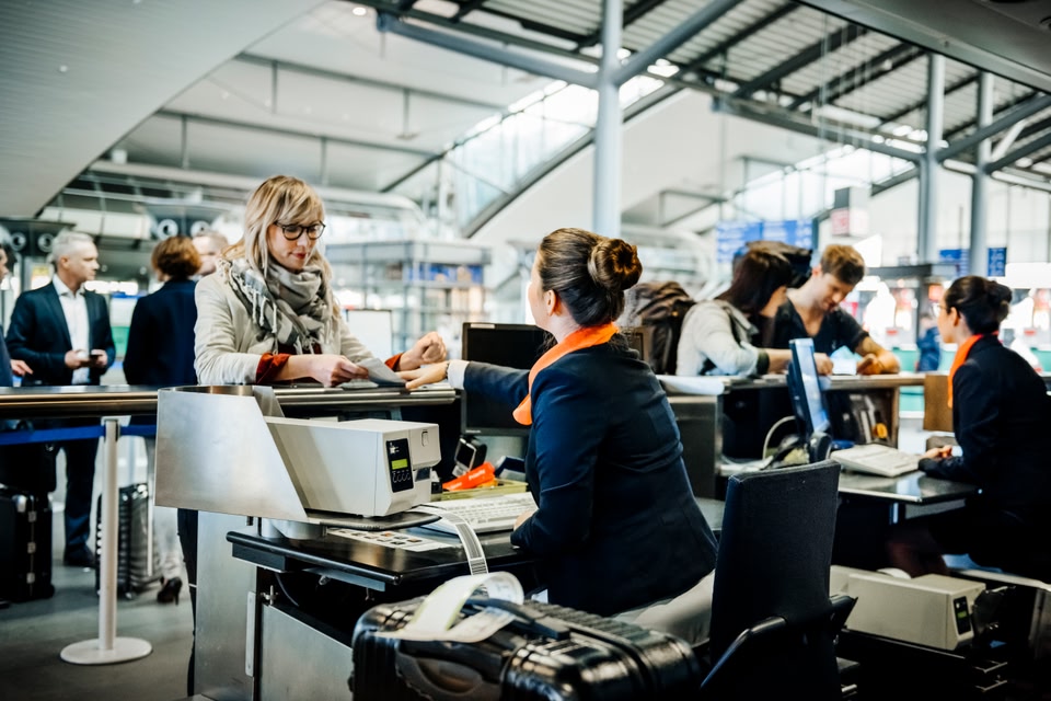 Woman at check-in counter talking to airport staff