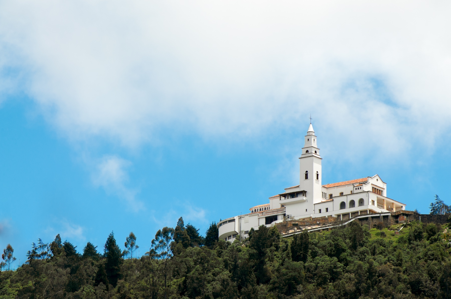 white church at the top of lush Monserrate. Visiting this destination is one of the free things to do in Bogota