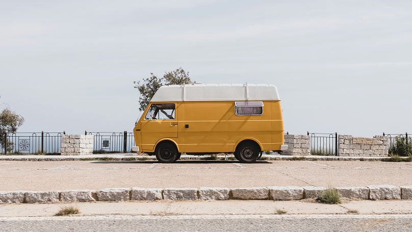 Gele camper aan Costa Smeralda, Sardinië