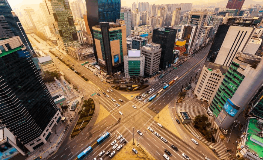 A bustling city intersection in Seoul captured from a bird's-eye view, depicting the vibrant flow of traffic and urban energy in action.