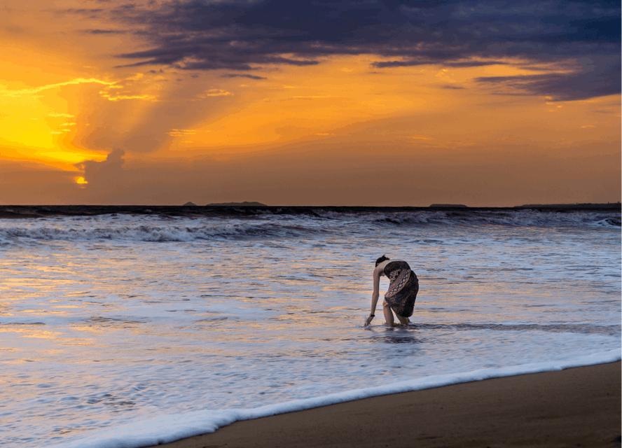 A person paddling during sunset on Colva beach