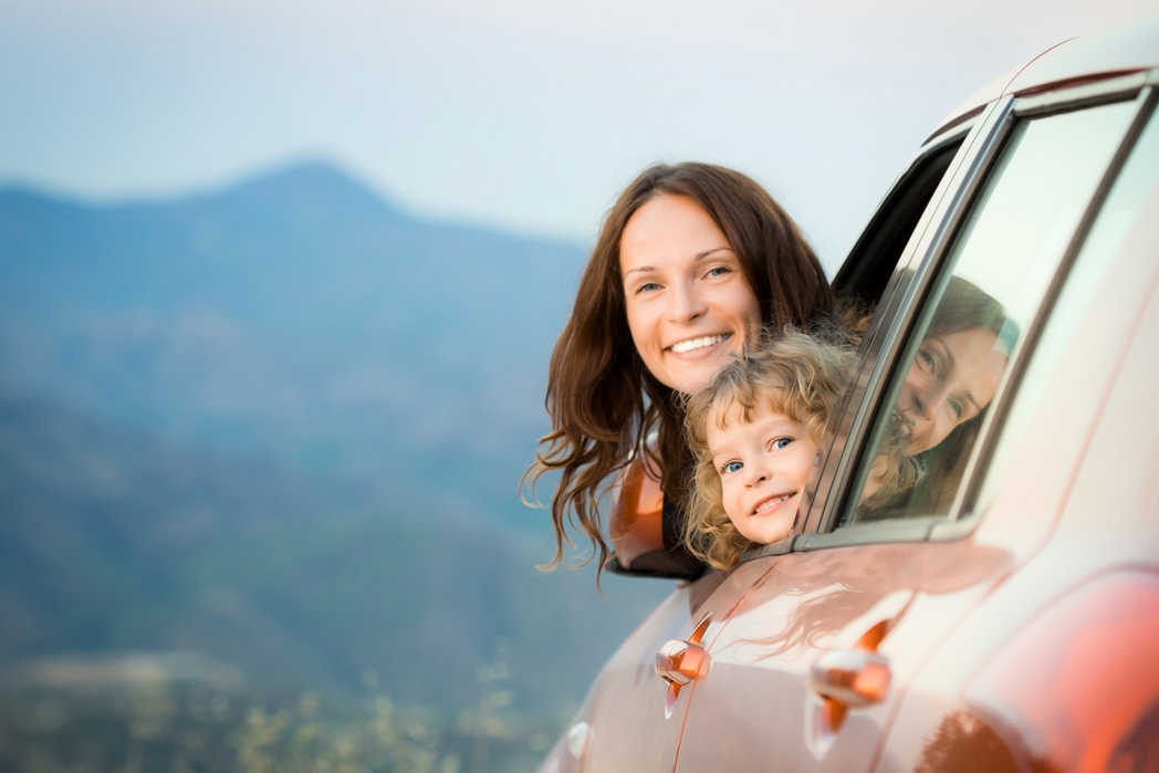 Mother and daughter popping their heads out of a car window