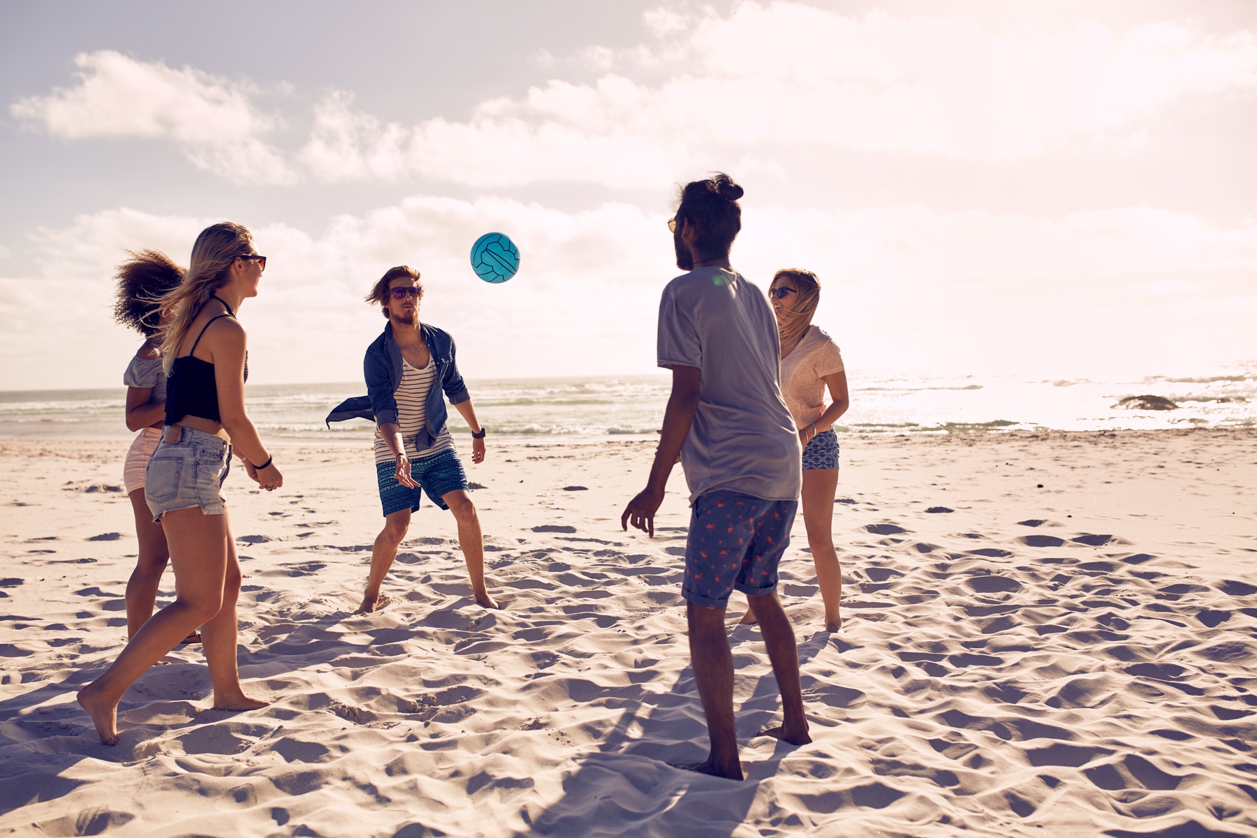 friends playing volleyball at the beach