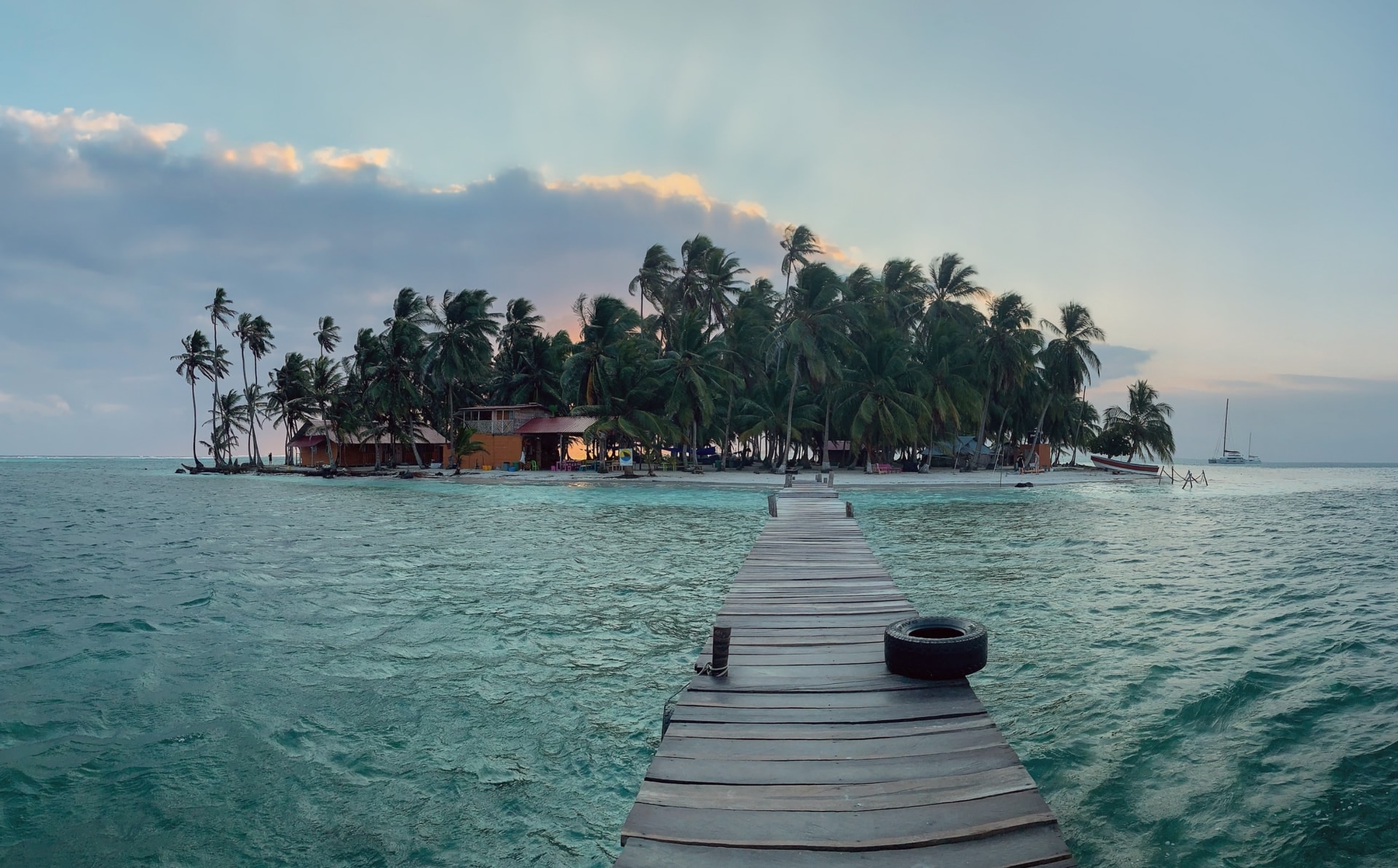A wooden pier stretches to one many palm tree covered islands in San Blas where you can put your work on hold.