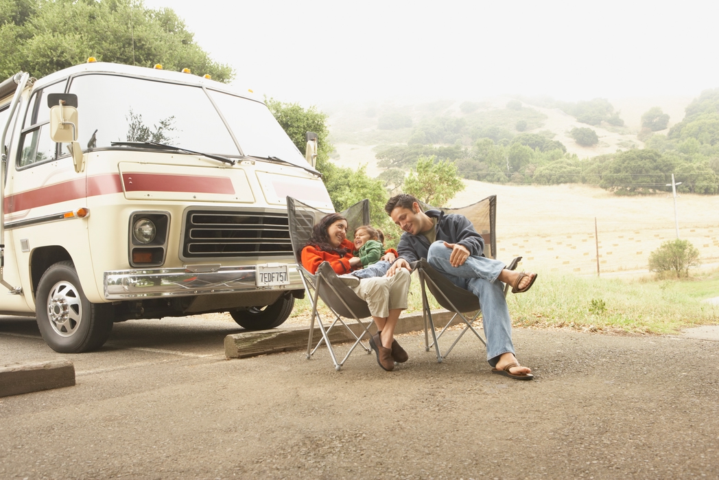 Family resting next to their camper van - road trip with the family