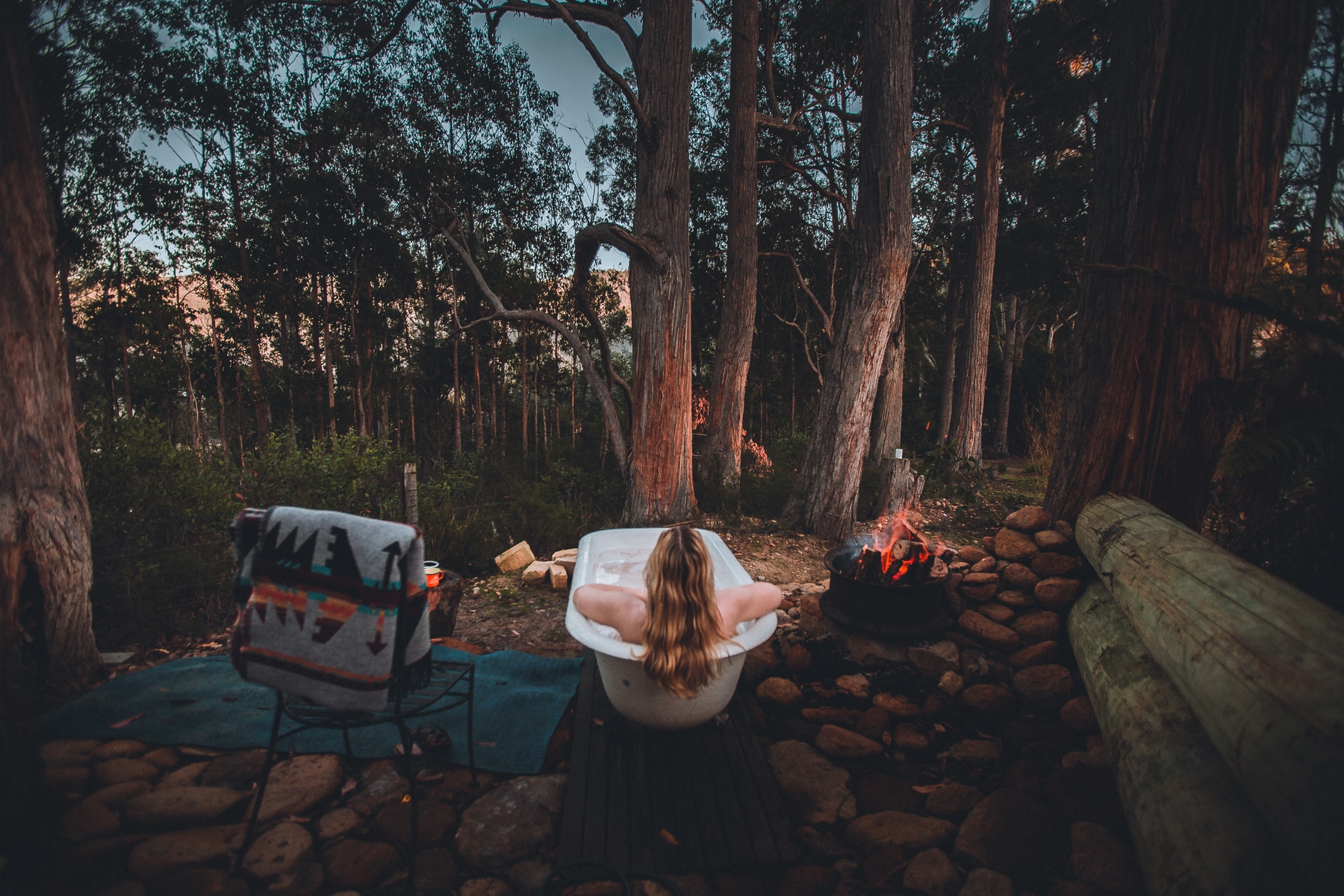 Girl relaxing in a hot tub at the Left of Field Camping Gardens