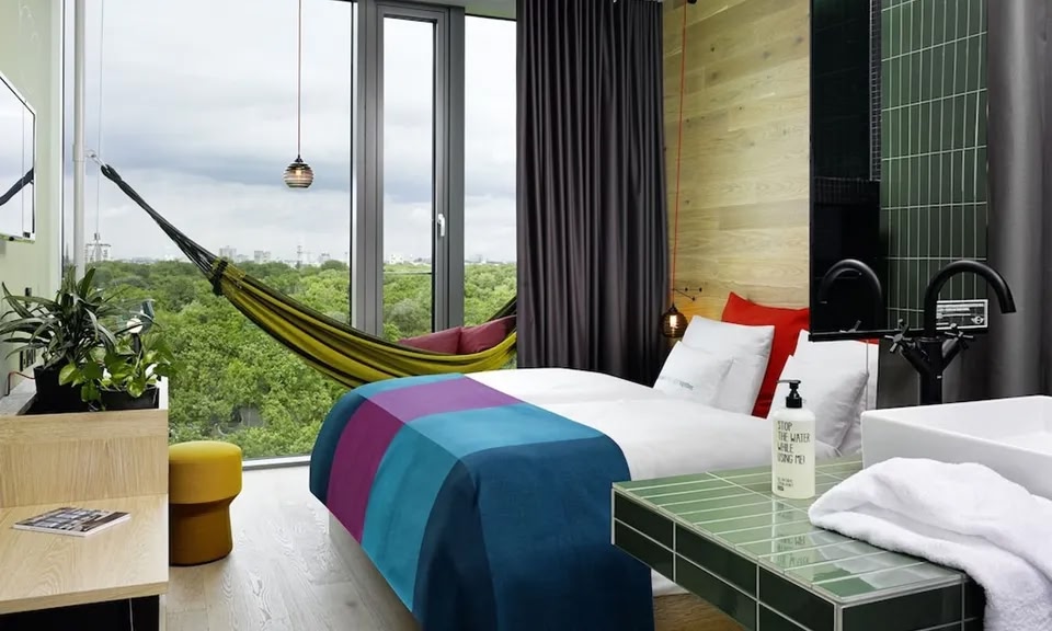 Una habitación en el 25hours Hotel Bikini Berlin con hamaca y vistas al Zoológico de Berlín.