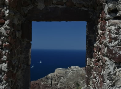 A stone archway with a view of Santorini sea