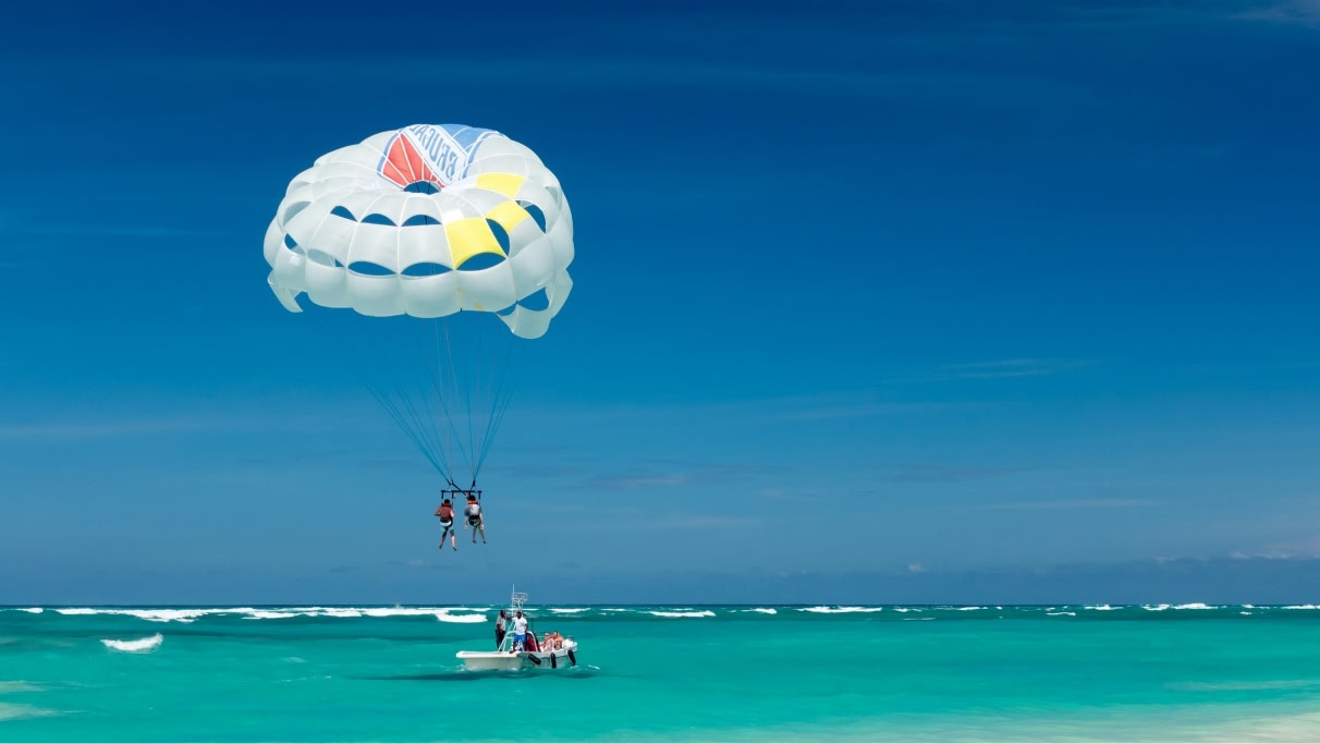 Two people paragliding near the blue ocean during the day. 