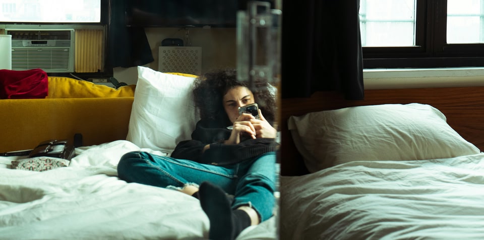 Woman in bed on her phone