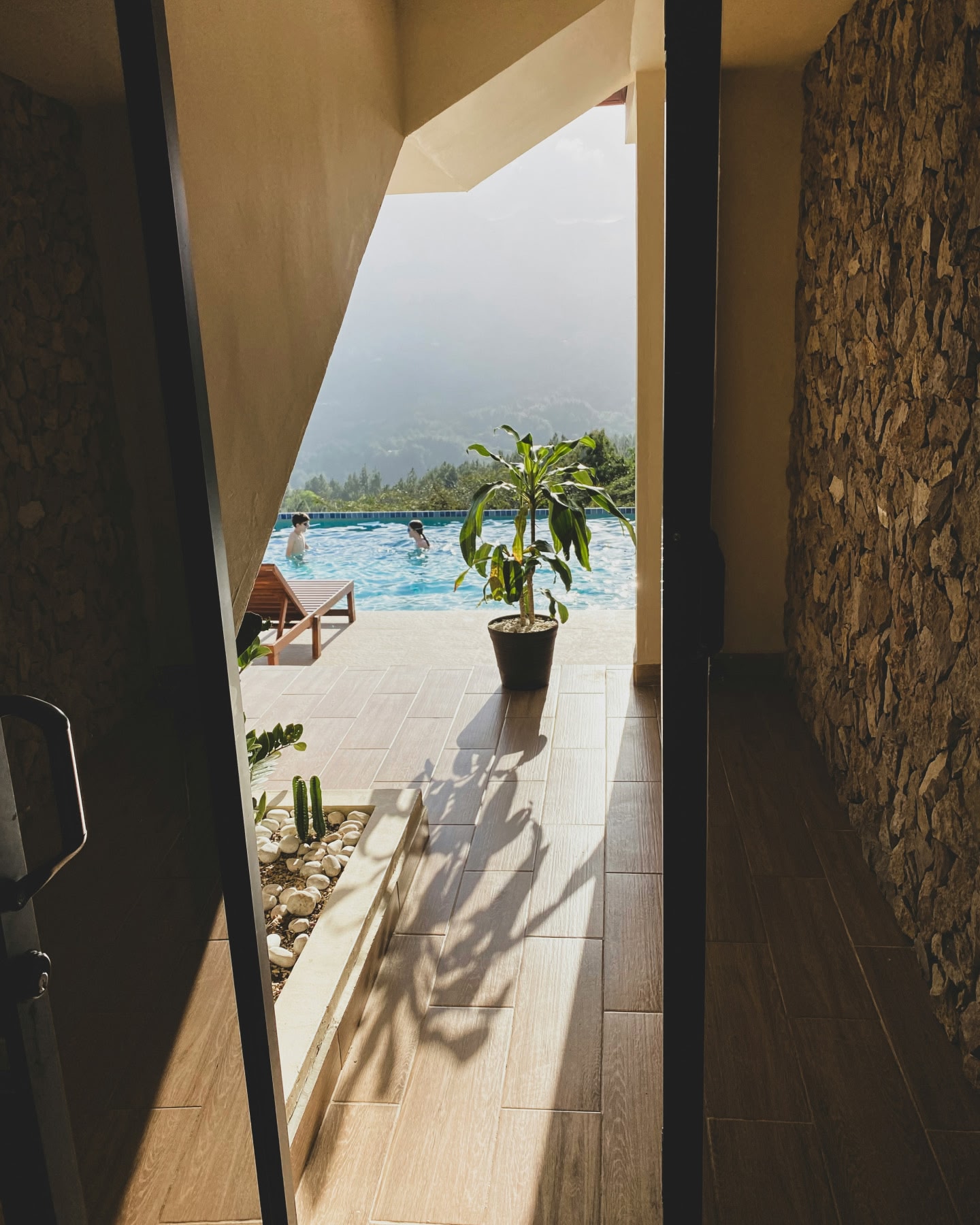 Two people in the pool at a peaceful villa overlooking mountains and trees in Panama