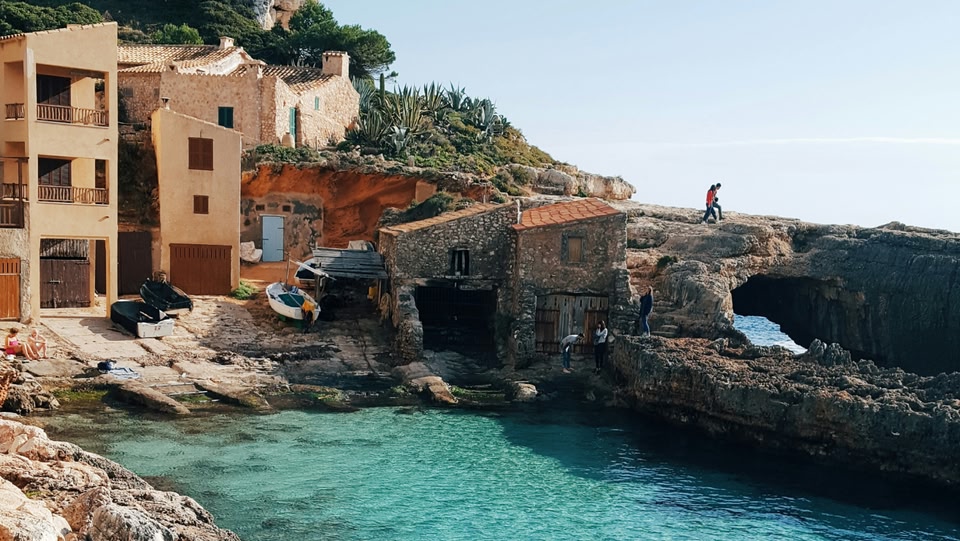 Paesaggio costiero con case e mare turchese.