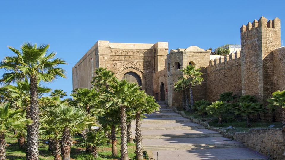 Kasbah of the Udayas in Rabat, Morocco, with palm trees and a stone staircase.