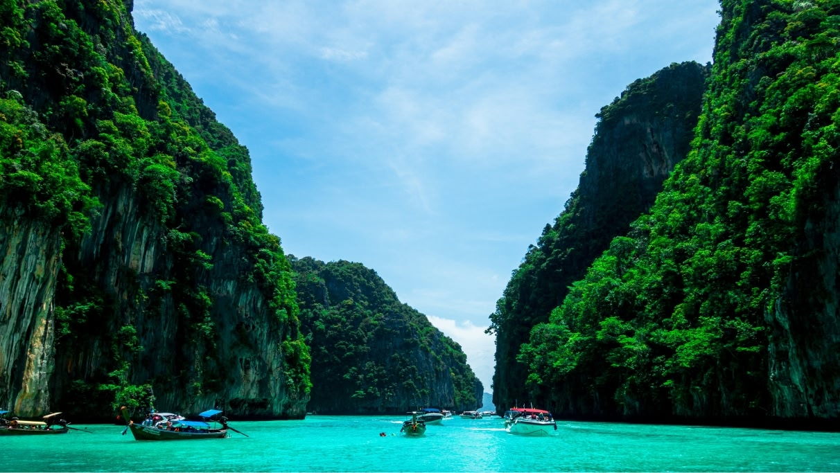 boats on the blue sea near green mountains on a sunny day