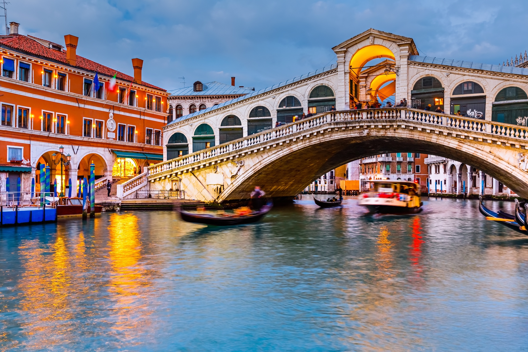 Gondolas sailing under a bridge in Venice