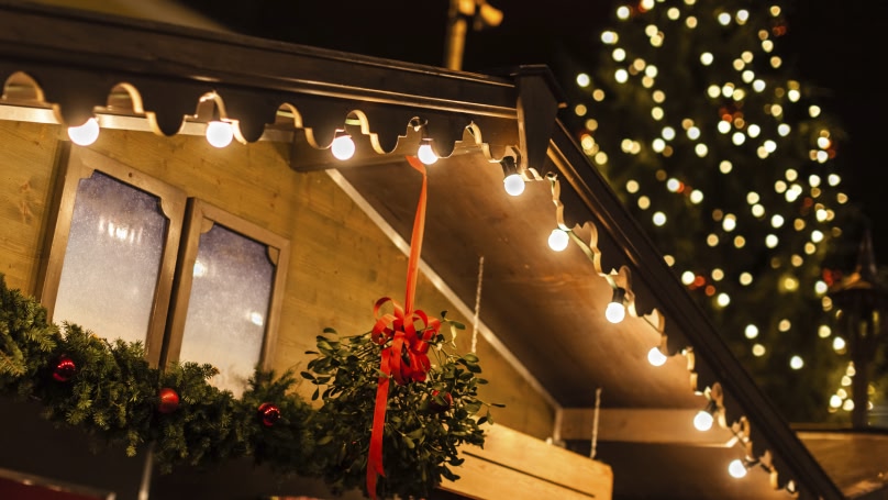 top of a christmas market stall with lights and mistle toe hanging from it