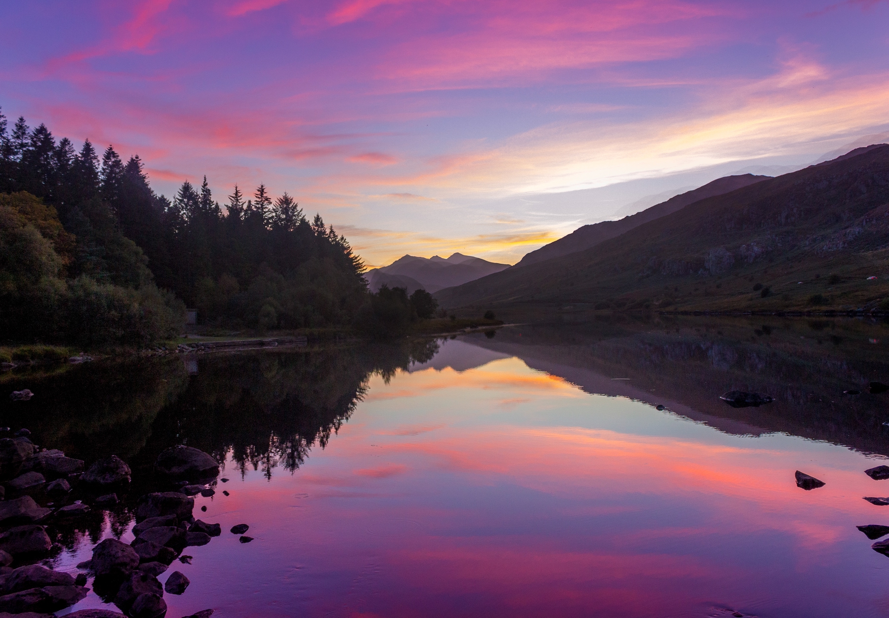 The sun sets over a rural Welsh lake - and after nightfall, the Brecon Beacons becomes one of the Northern Lights hotspots in the UK