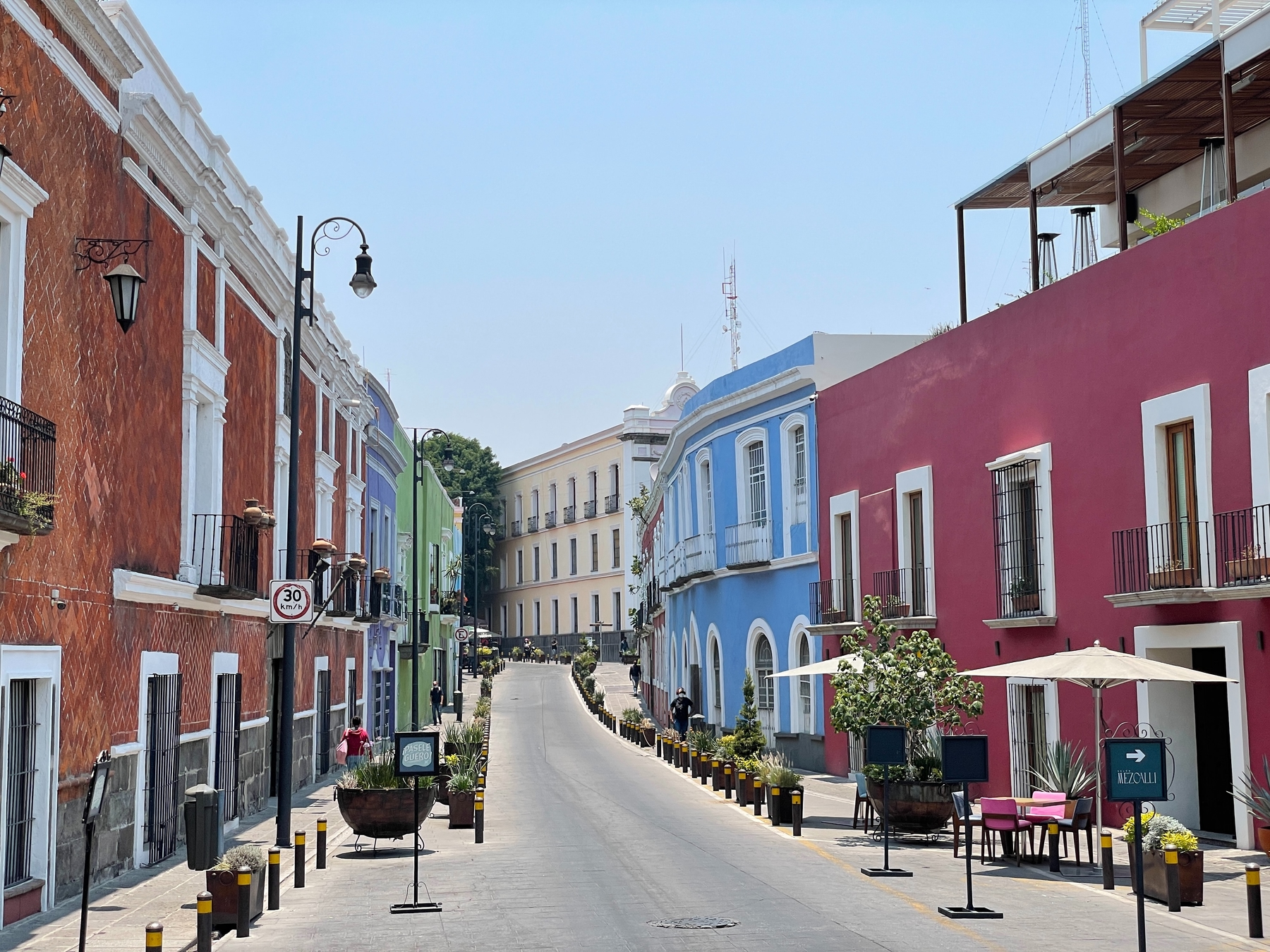 Colourful pastel buildings on a main street in Puebla City, Mexico, an underrated alternative to visiting Mexico City.