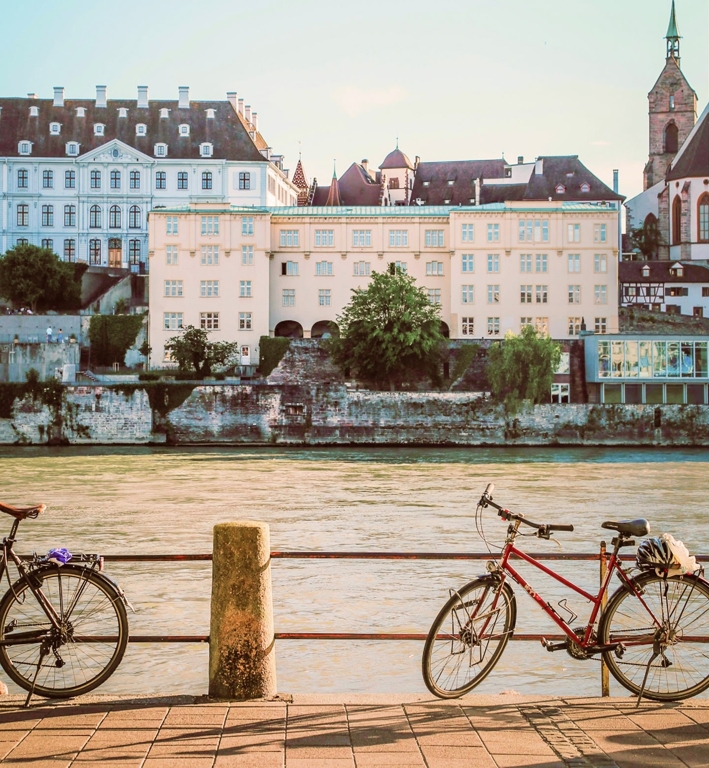 Bicycles leaning against railings beside the Rhine River in Basel, Switzerland