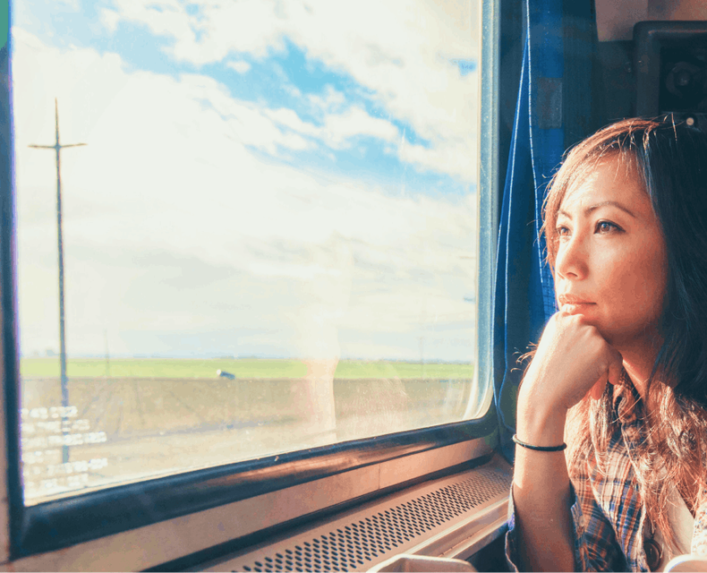 A woman looking out of a train on her way to Tokyo from Narita airport. She could have secured her seat after reading the Skyscanner Tokyo travel guide. 