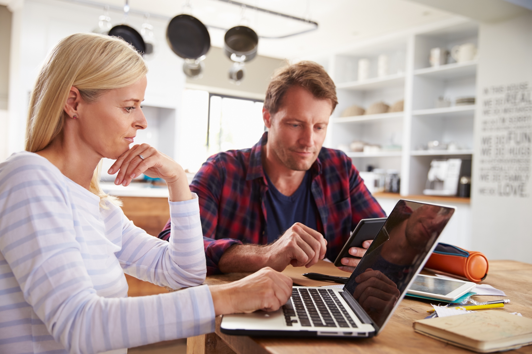 a couple sitting at their table planning on their laptop