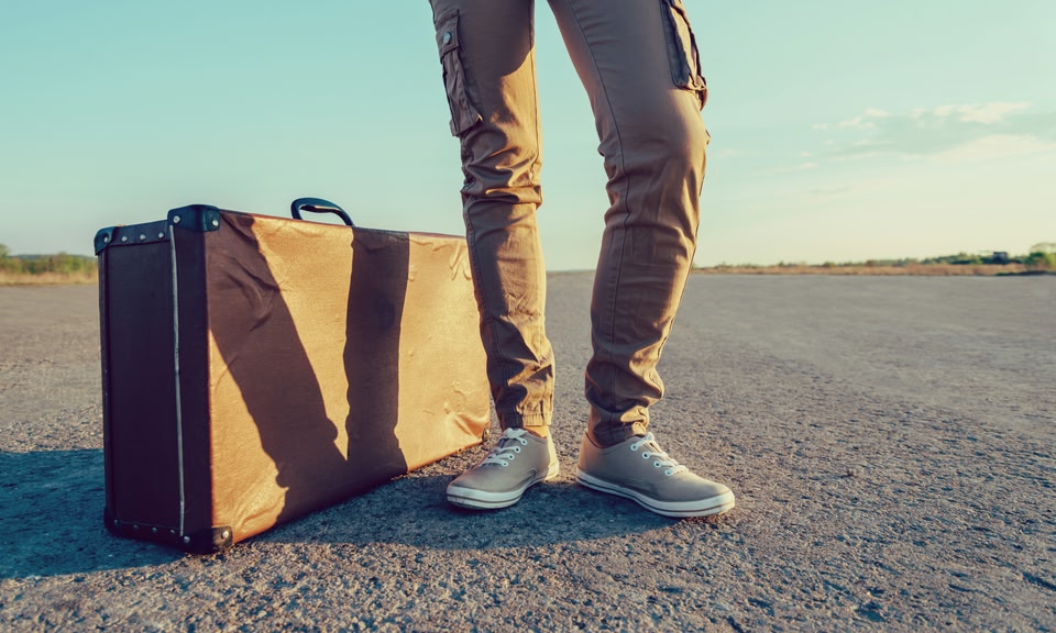 Man travelling with a vintage suitcase - weekend getaways in Ireland