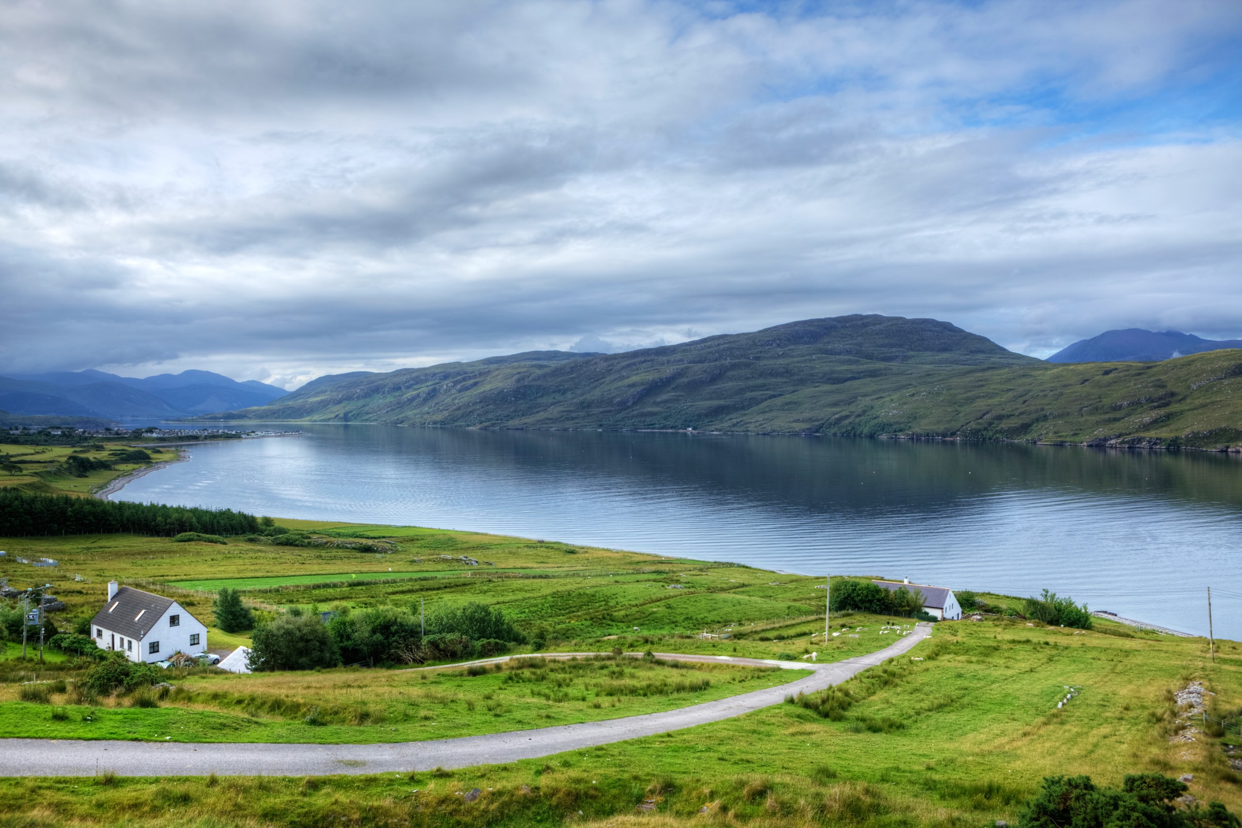Strada stretta nelle Highlands scozzesi. Sullo sfondo il Loch Broom a Ullapool.