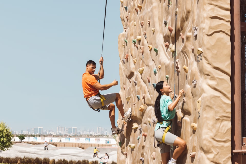 Ein asiatisches Paar beim Klettern im Circuit X, einem Outdoor-Freizeitpark in Abu Dhabi.