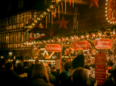 groep mensen die 's avonds op kerstmarkten lopen