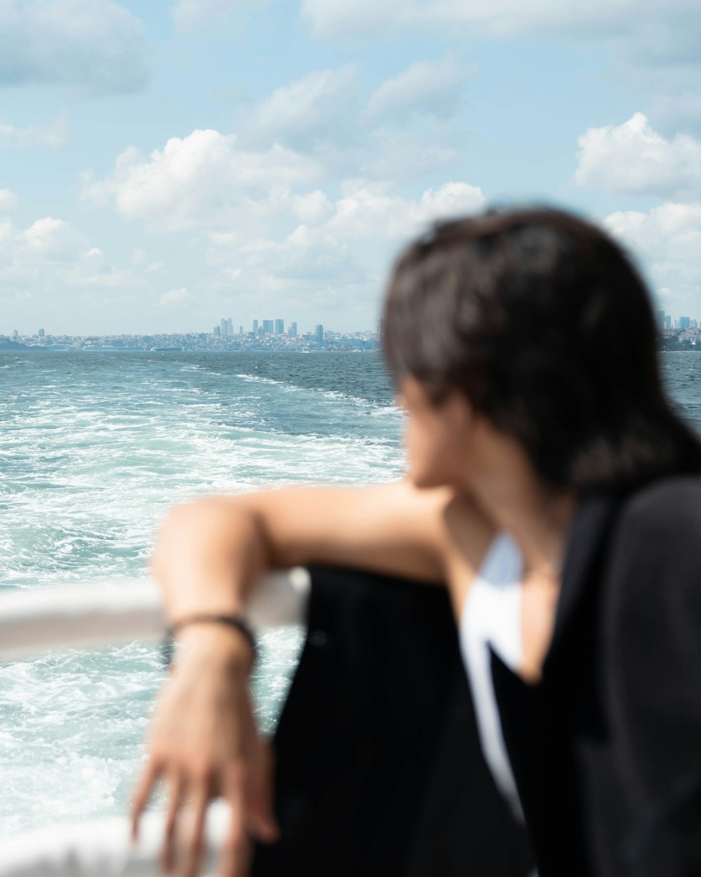 Traveller looks back to cityscape from a boat