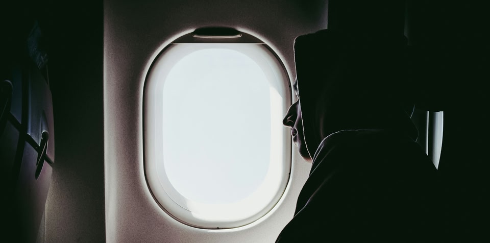 Man on plane looking out of window