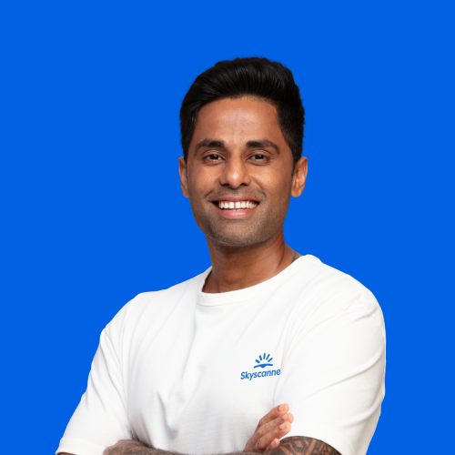 Indian cricketer Suryakumar Yadav, wearing a white t-shirt against a blue background.