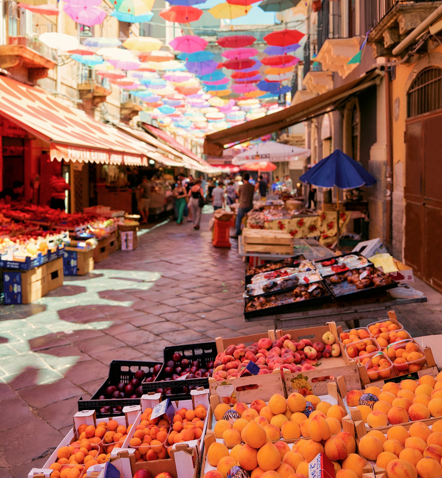 Des gens font leurs achats dans un marché en plein air à Catane, en Sicile.