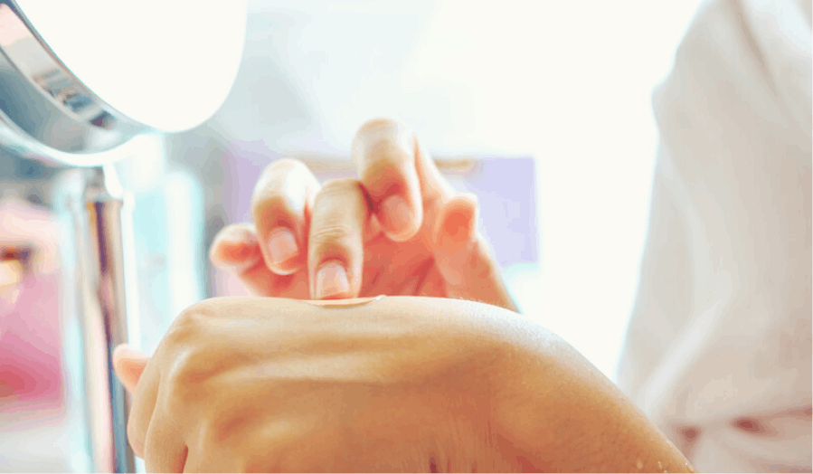 A close-up of a woman indulging in self-care, applying nourishing hand cream.