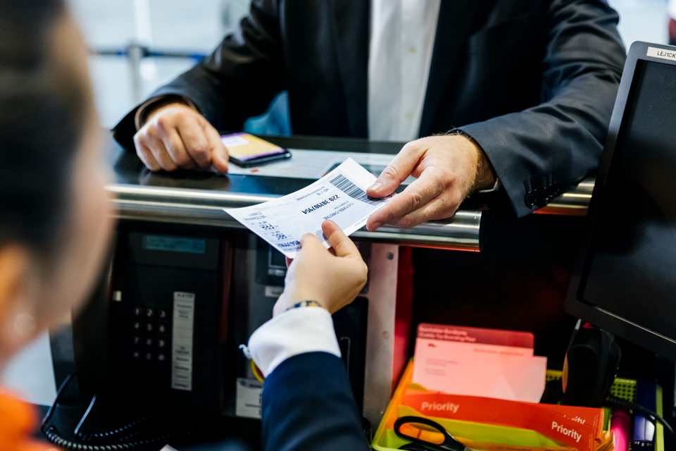 Person handing airport staff their boarding pass