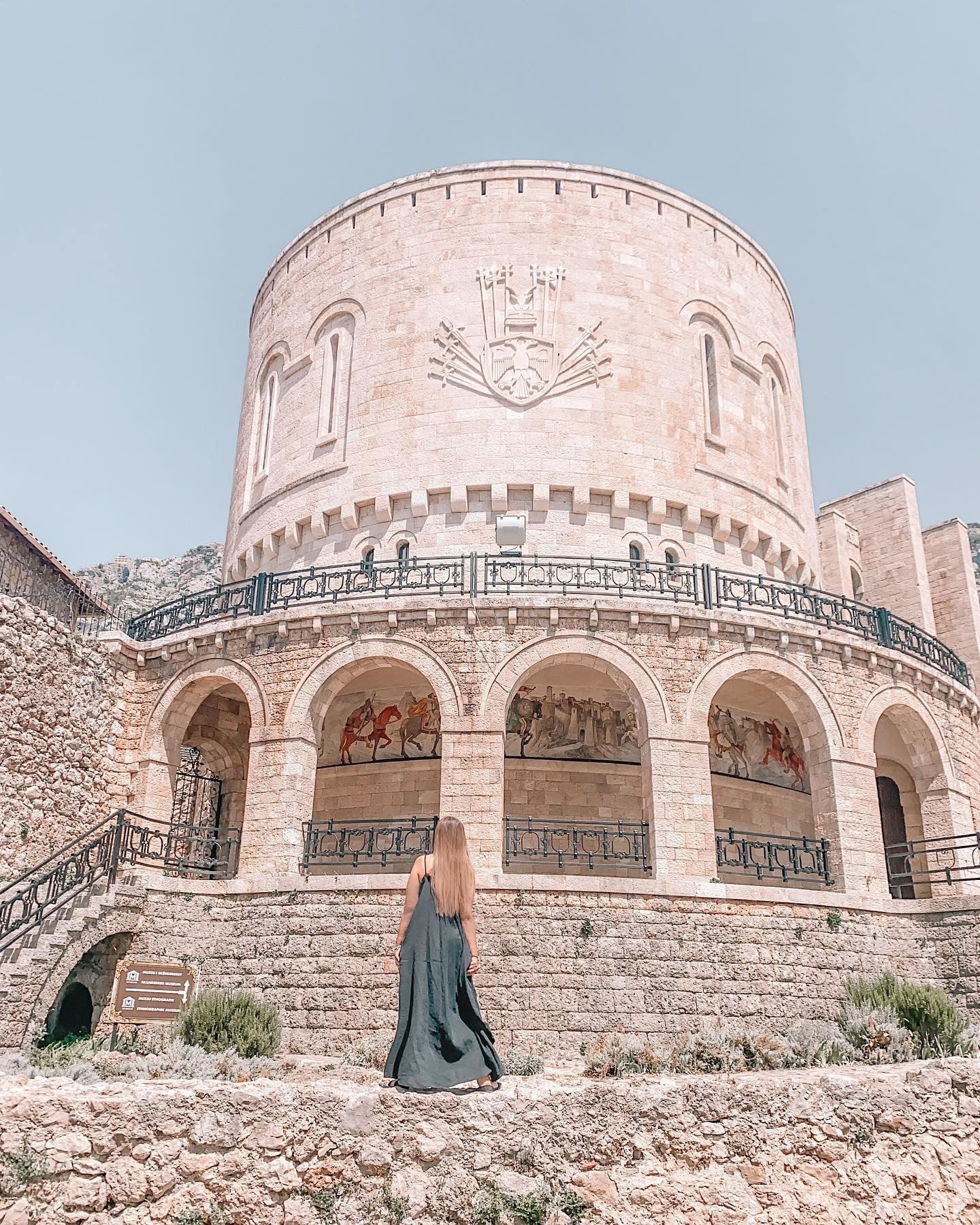 Woman standing in front of Krujë Castle in Albania. 
