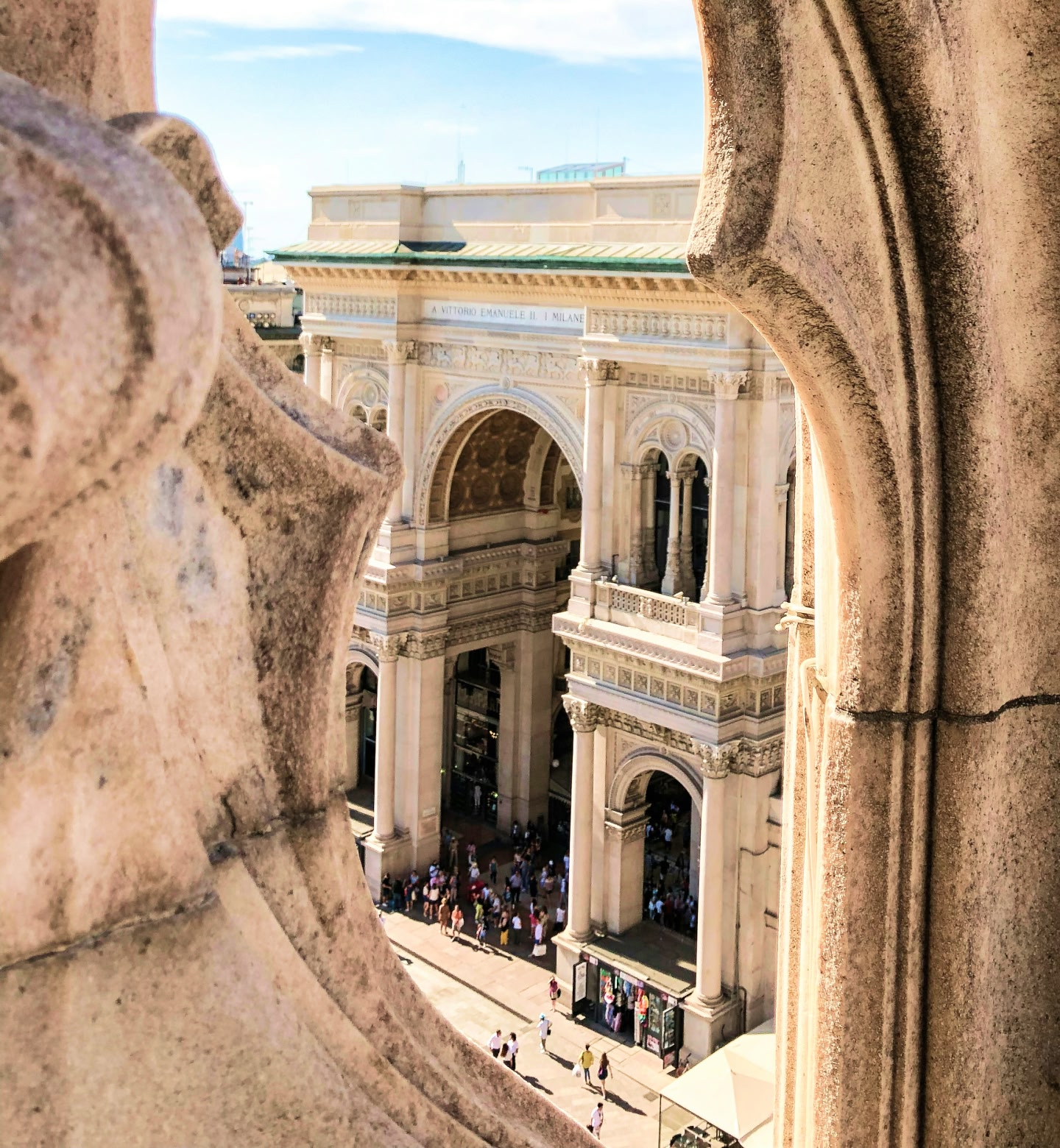 View of Galleria Vittorio Emanuele II framed by Milan cathedral stone.