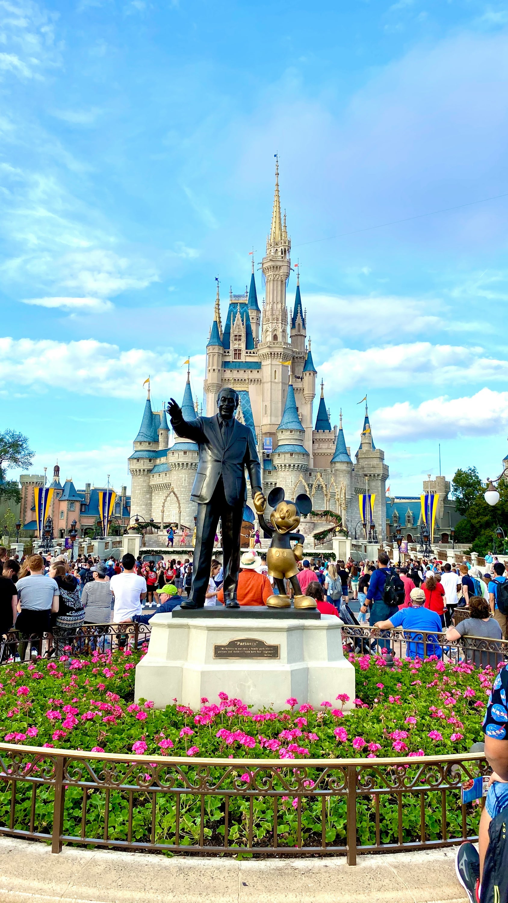 Walt Disney and Mickey Mouse statue in front of Cinderella's castle in Magic Kingdom theme park.