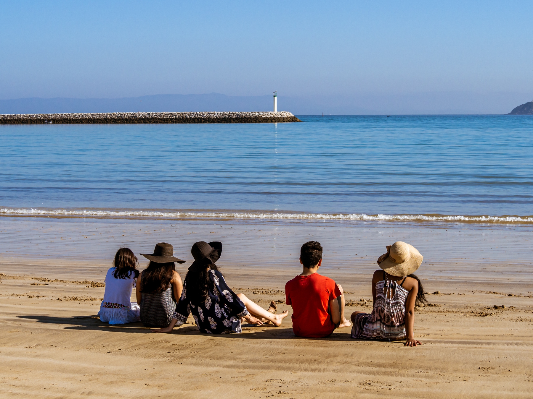 Rear view of people sitting on the municipal beach of Tangier in northern Morocco