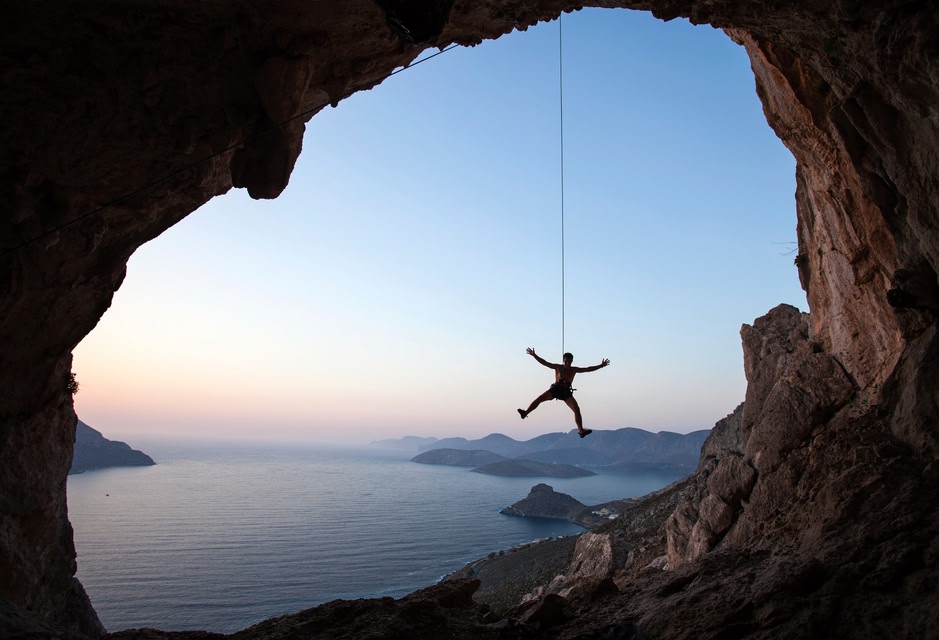 Climber watching sea view at rock window on Kalymons - best Greek island to vist for adventurers