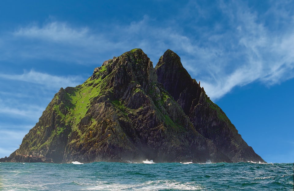 View of Skellig Michael rising up out of the sea with blue skies