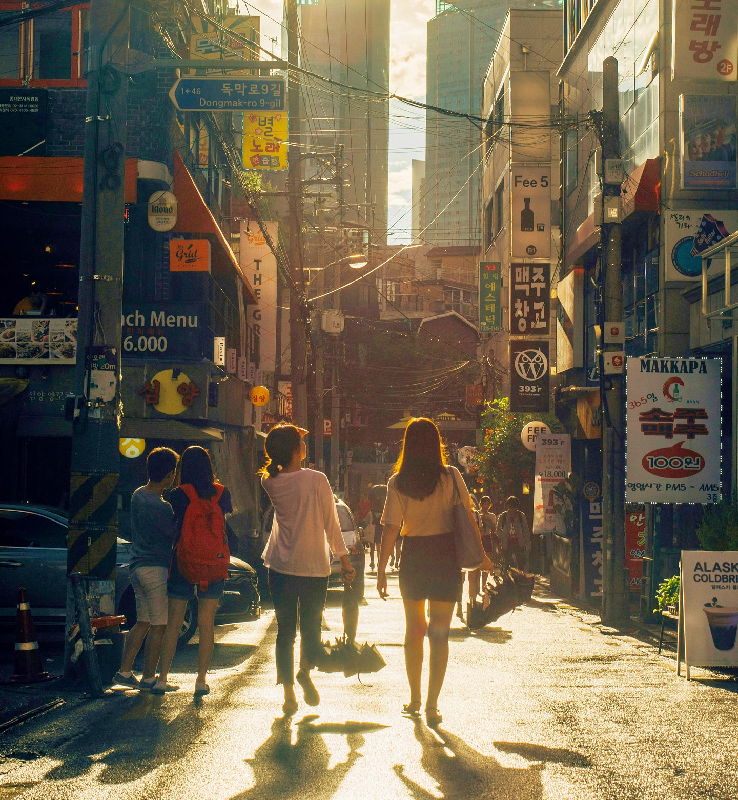 Late sunshine floods a busy urban street in Seoul, South Korea.