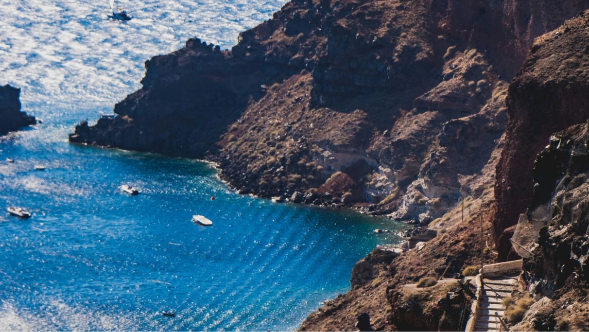 Vista panoramica della scogliera di Santorini col suo mare blu durante il giorno. 