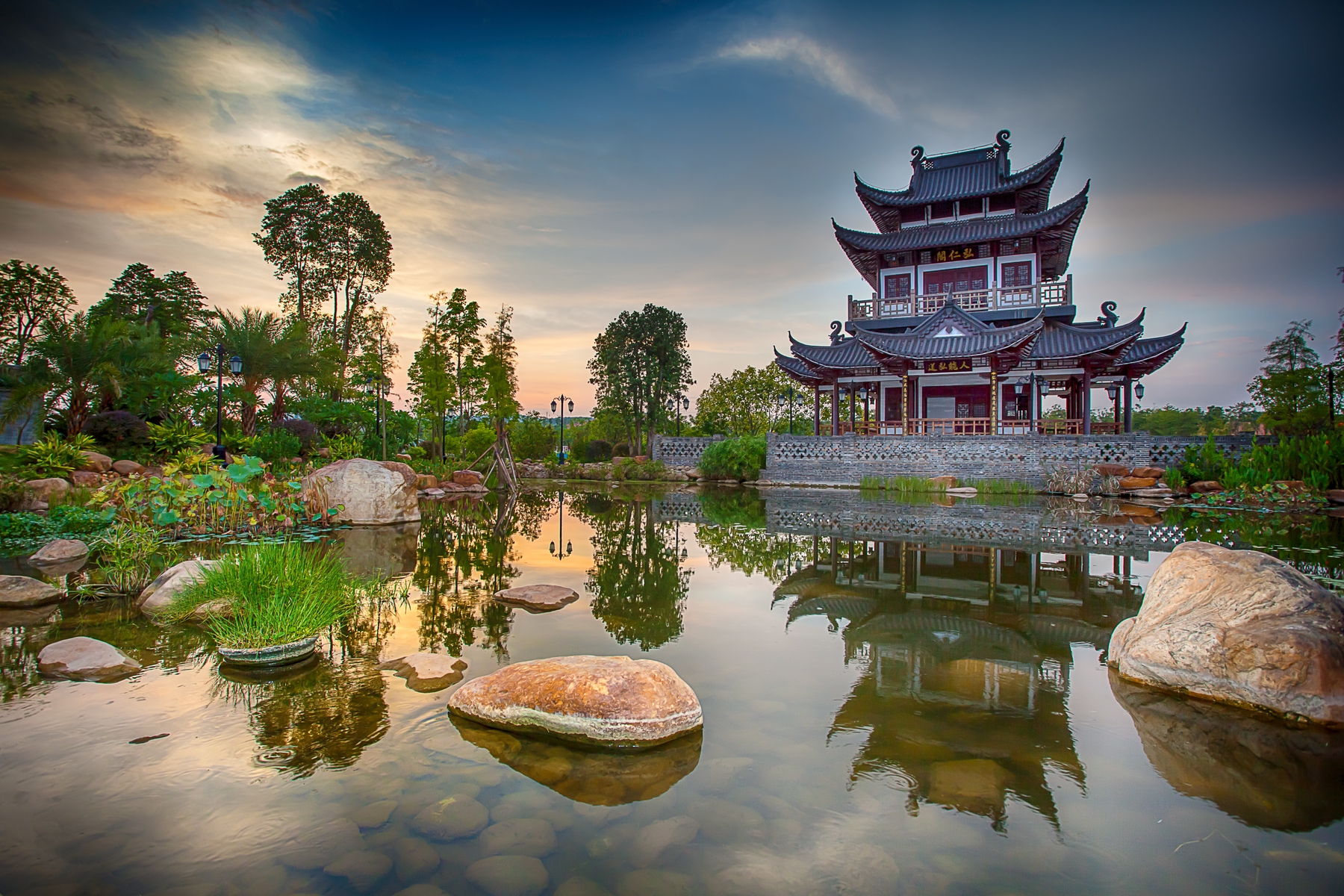 A hong kong temple near a pond