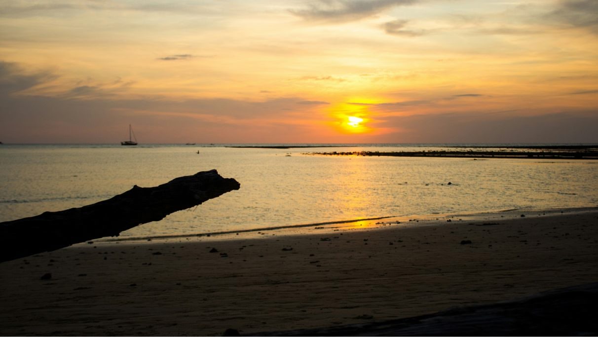 an image of the sun setting over the water at the beach.