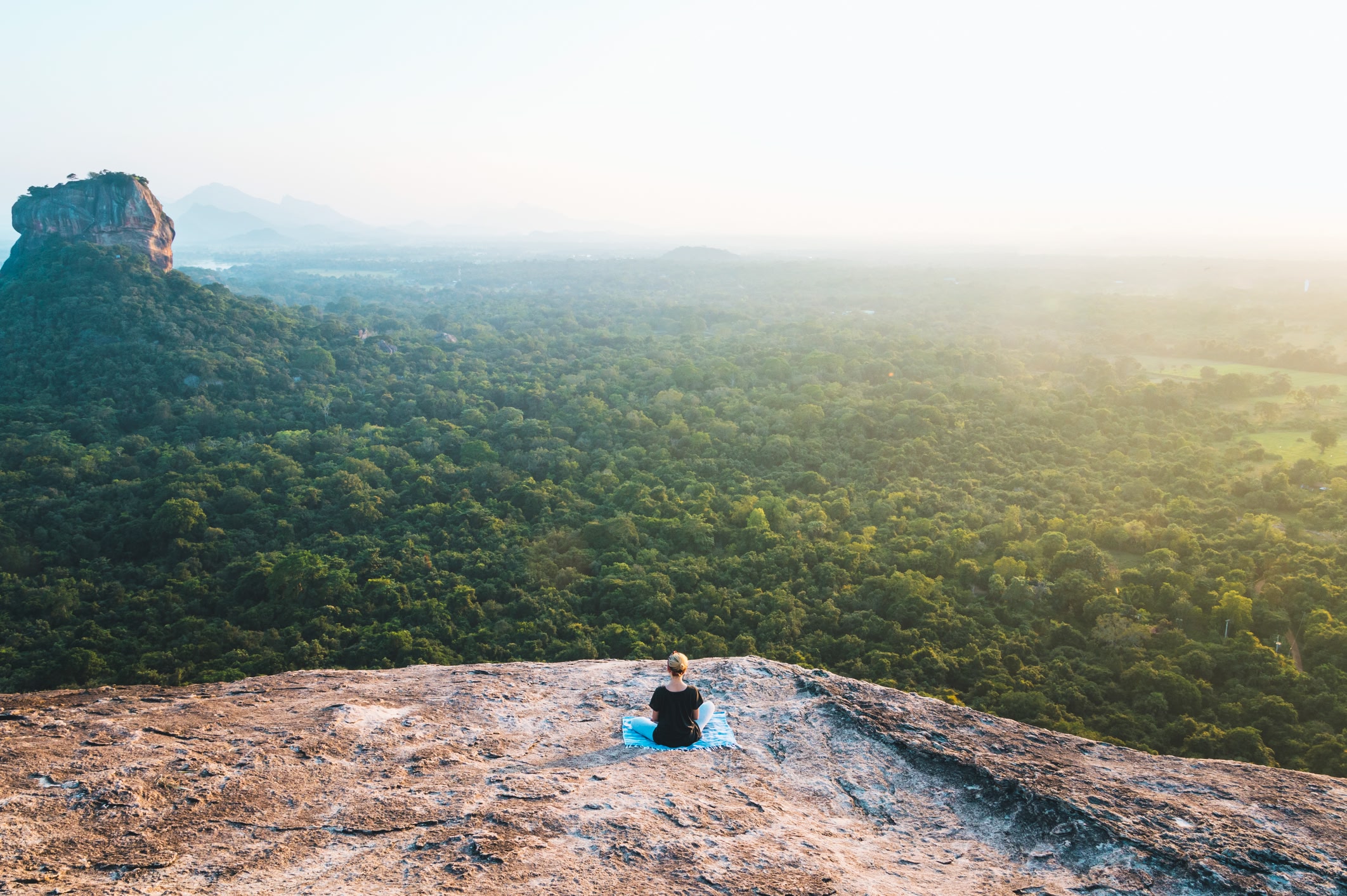 Traveller peacefully sitting on the top of Pidurangala Rock, Sigiriya.