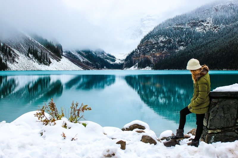 woman with winter coat and hat in snowy Lake Louise, Alberta