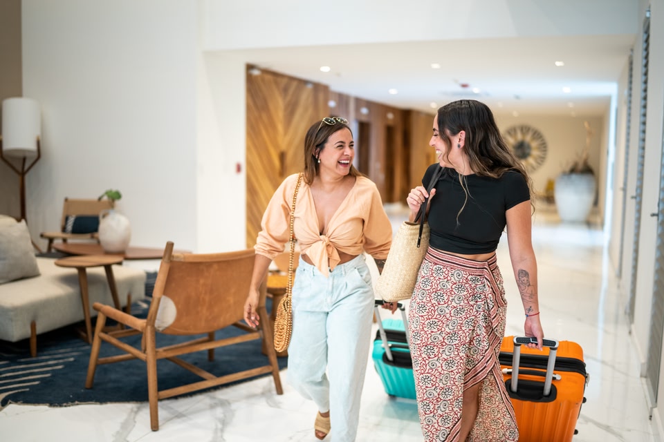 amigas em um saguão de hotel com bagagem de mão Azul voos nacionais