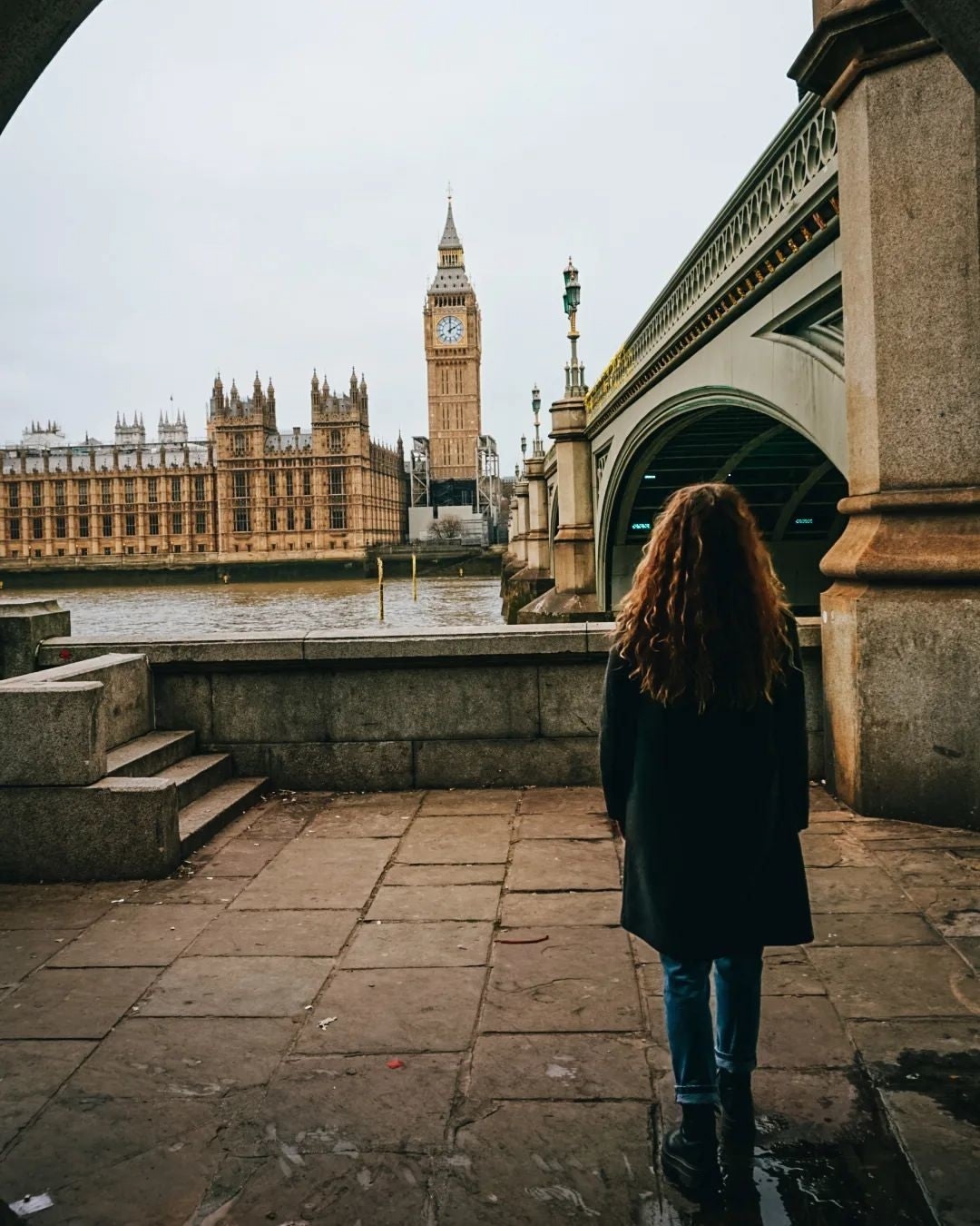 London Houses of Parliament and Big Ben seen by a tourist across the Thames