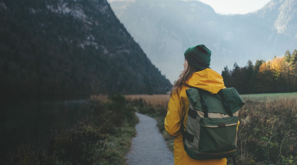 mulher de costas para a câmera fazendo uma trilha nas montanhas - hiking e trekking